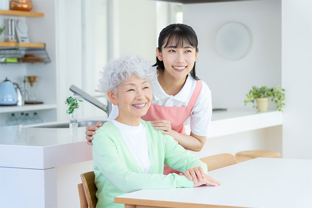 自宅で介護スタッフが利用者を笑顔でサポートしている様子